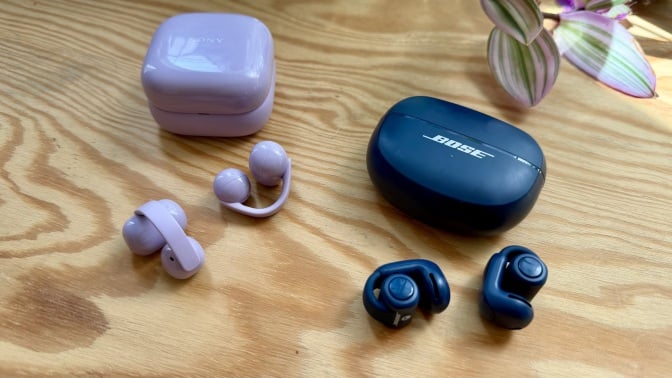 purple sony linkbuds clip next to blue bose ultra open earbuds on wooden table next to purple and green plant