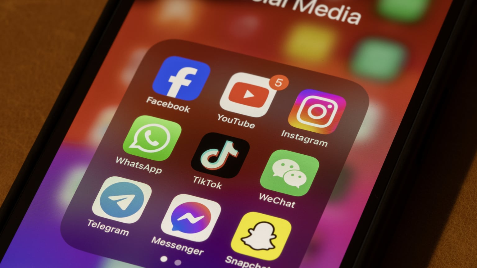 Social media appas are visible on a close-up of a smartphone screen.