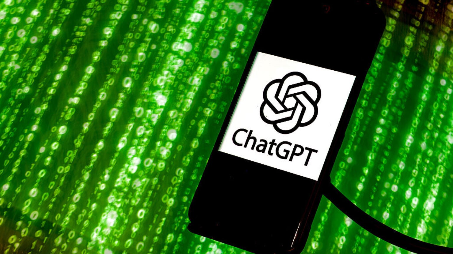 ChatGPT logo on phone screen in front of a green Matrix scroll