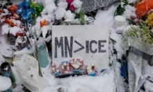 A sign reading "MN > ICE", surrounded by snow-covered flowers.