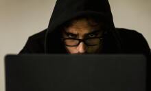 Man in hood looking at screen
