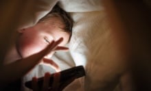 A child scrolls on a smartphone.