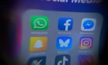 blurry social media icons on iphone screen with Bluesky app in center