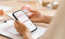 woman holding phone with save the date on screen