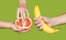 Banana and grapefruit in hands isolated on a green background as a symbol of male and female masturbation. 