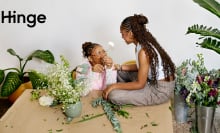 two black woman looking at each other, surrounded by plants