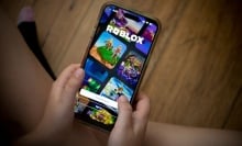 Child plays Roblox on a smartphone. 