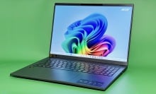 Acer Aspire 16 AI laptop open to Windows 11 homescreen on green background