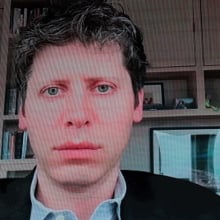 OpenAI CEO Sam Altman speaks remotely on a screen