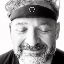 A man with the elemind headband, smiling with eyes closed