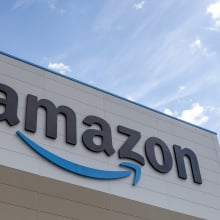 A large Amazon logo sign on the side of a warehouse.