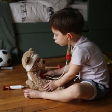Boy plays with a stuffed bear.