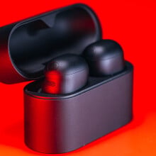 sony xm6 earbuds in charging case on red background