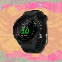 garmin forerunner 55 against a pink, yellow, and green patterned background