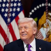 President Trump grimaces in front of a U.S. flag.