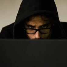 Man in hood looking at screen