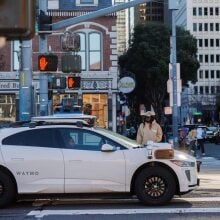 A white Waymp vehicle waiting at a Chicago intersection.
