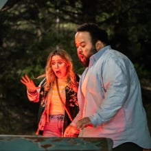 Maria Bakalova and Zach Cherry look terrified opening a car trunk in a still from "All Night Wrong."
