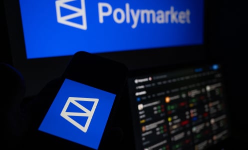 A large computer screen and a phone screen display the Polymarket logo. A small laptop shows a live market feed.