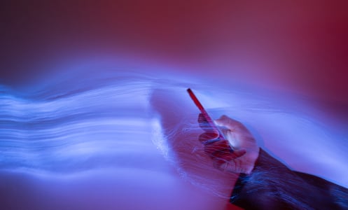 hand holding smartphone on holographic background