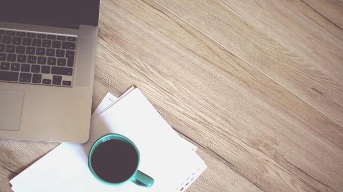 Laptop and coffee mup on table