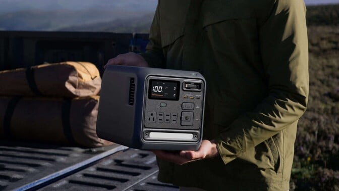 the DJI Power 1000 Mini being carried by a person who's standing near a truck outside