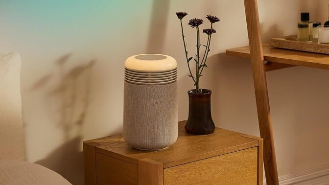 the Blueair mini restful air purifier sits in a bedside table in dim lighting.