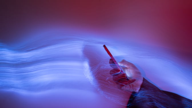 hand holding smartphone on holographic background