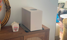Dreame food waste disposer, takeout container, and decor sitting on wooden credenza in living space