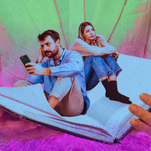 A man and woman sit inside the open pages of a book, the man turns his back on the woman while he stares at is phone. 