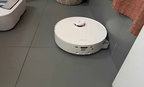 Roborock Qrevo Curv 2 Flow robot vacuum mopping gray tile bathroom floor near shower