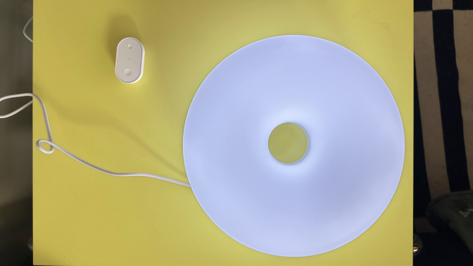 The smart IKEA Varmblixt lamp on a table with its remote.